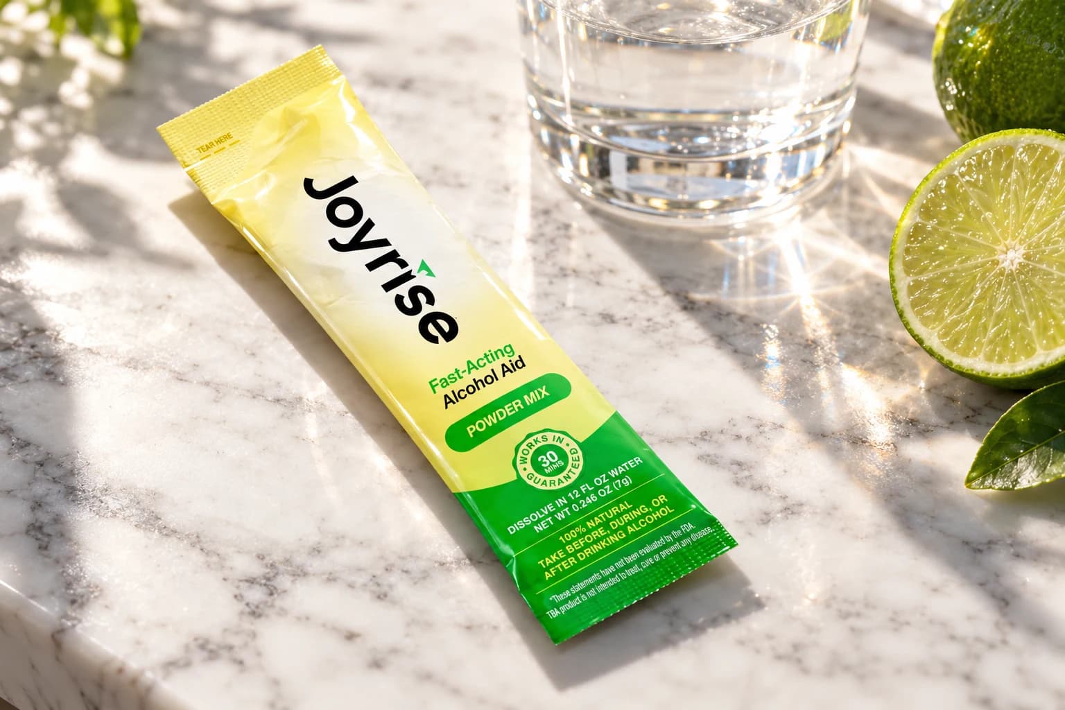 Joyrise powder stick beside water and lime on a sunlit marble counter
